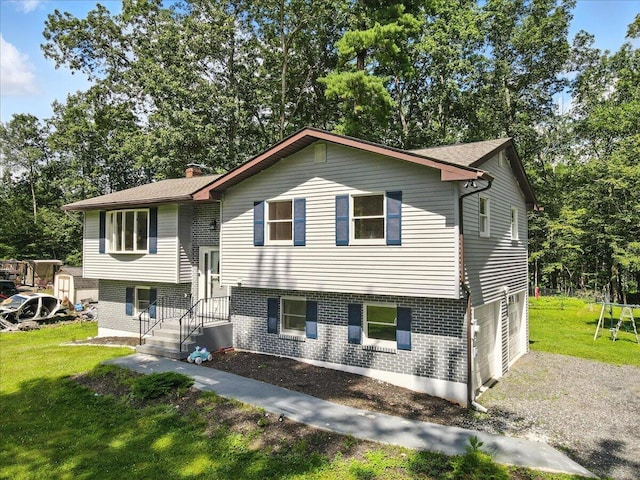 52 Bull Pine Rd, East Stroudsburg, PA 18301 - bi-level home with an attached garage, brick siding, a front yard, a chimney, and view of wooded area