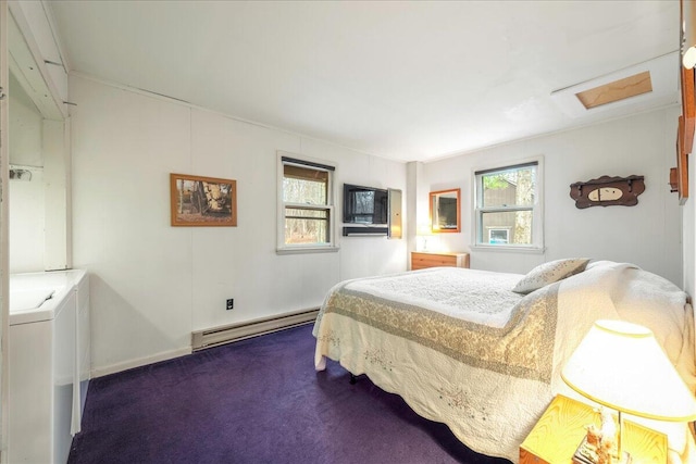 bedroom featuring a baseboard heating unit, attic access, washer / clothes dryer, and dark carpet