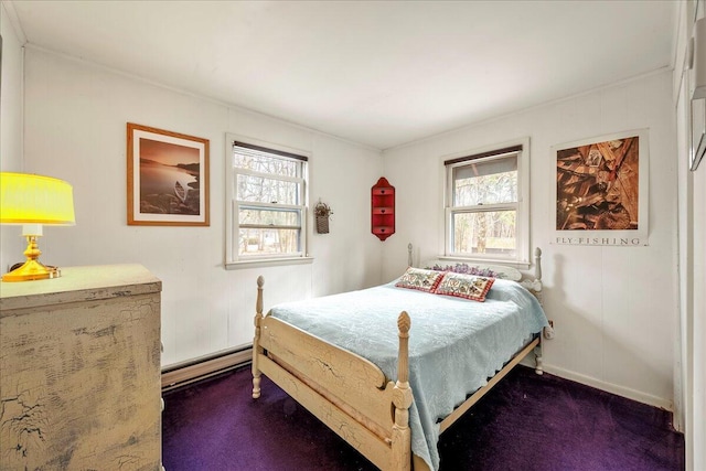 bedroom with a baseboard heating unit, dark carpet, and multiple windows