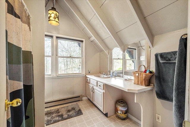kitchen with a baseboard radiator, a sink, hanging light fixtures, lofted ceiling with beams, and light countertops