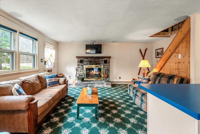 living room featuring carpet flooring, a textured ceiling, and a fireplace