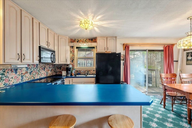 kitchen with a peninsula, a textured ceiling, a sink, and black appliances