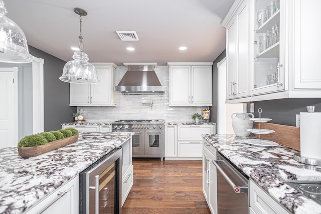 kitchen featuring visible vents, stainless steel appliances, dark wood-type flooring, wine cooler, and wall chimney exhaust hood