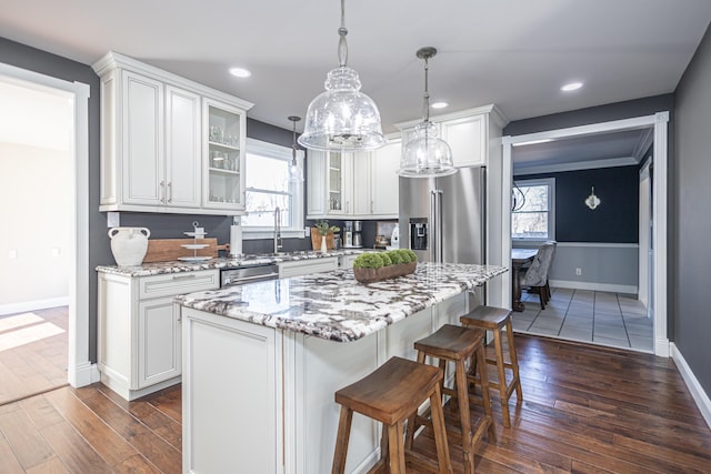 kitchen with white cabinets, appliances with stainless steel finishes, and dark wood-style flooring