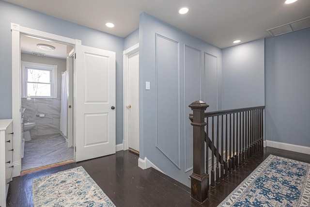 corridor featuring visible vents, baseboards, an upstairs landing, recessed lighting, and wood finished floors