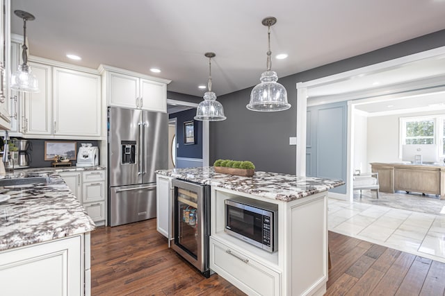 kitchen featuring dark wood-type flooring, light stone counters, wine cooler, appliances with stainless steel finishes, and white cabinets