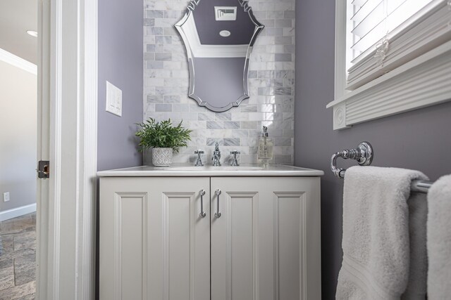 bathroom with visible vents, ornamental molding, tasteful backsplash, baseboards, and vanity