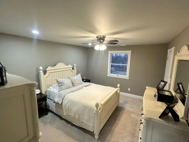 bedroom with light carpet, a ceiling fan, and baseboards