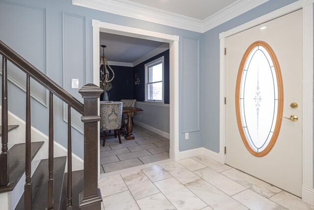 foyer entrance featuring baseboards, marble finish floor, ornamental molding, and stairs