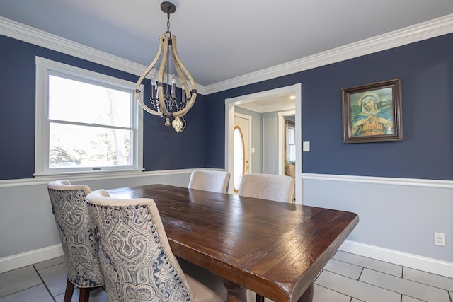 dining area with an inviting chandelier, tile patterned floors, crown molding, and baseboards