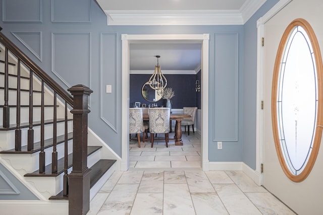 entrance foyer featuring a chandelier, stairway, marble finish floor, and ornamental molding