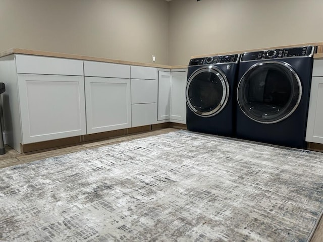 washroom with cabinet space and washer and clothes dryer