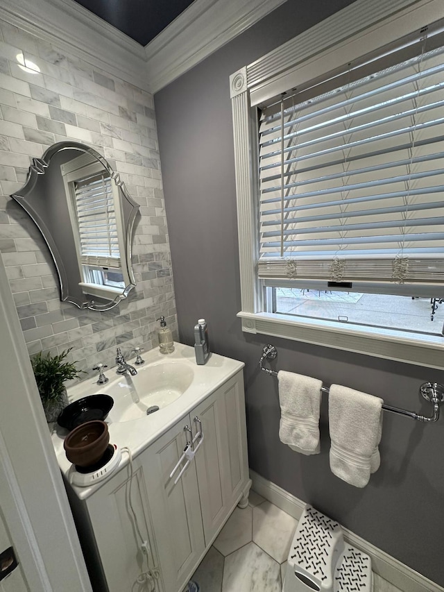 bathroom with vanity, baseboards, backsplash, and ornamental molding