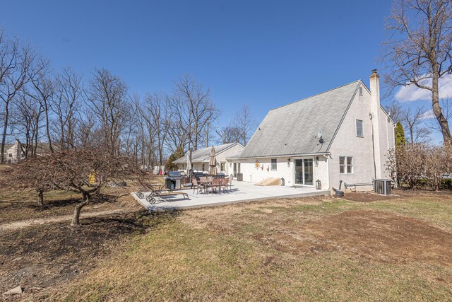 rear view of house featuring a chimney, central AC, and a patio