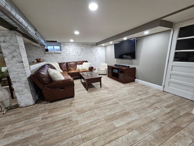 living room featuring recessed lighting, baseboards, brick wall, and wood tiled floor