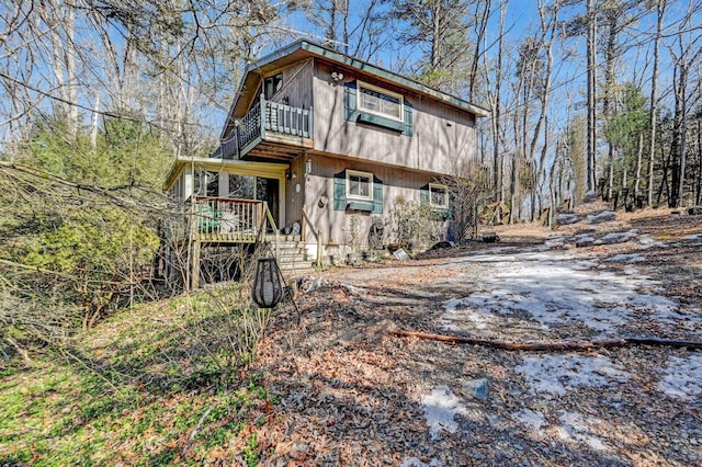 view of front of house with driveway and a balcony