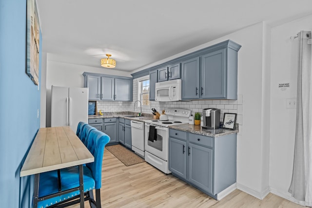 2255 Whippoorwill Dr, Tobyhanna, PA 18466 - kitchen with backsplash, a sink, light wood-style flooring, and white appliances