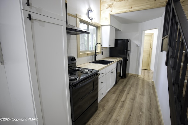 kitchen with a sink, white cabinets, light countertops, backsplash, and black appliances