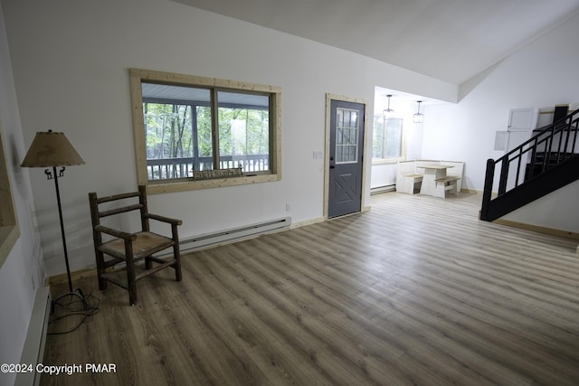 living area with lofted ceiling, stairway, baseboard heating, and wood finished floors