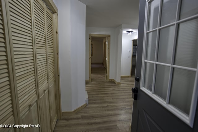 hall with baseboards and wood finished floors