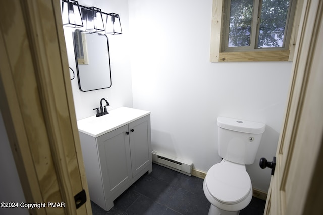 half bath with a baseboard heating unit, baseboards, vanity, and toilet