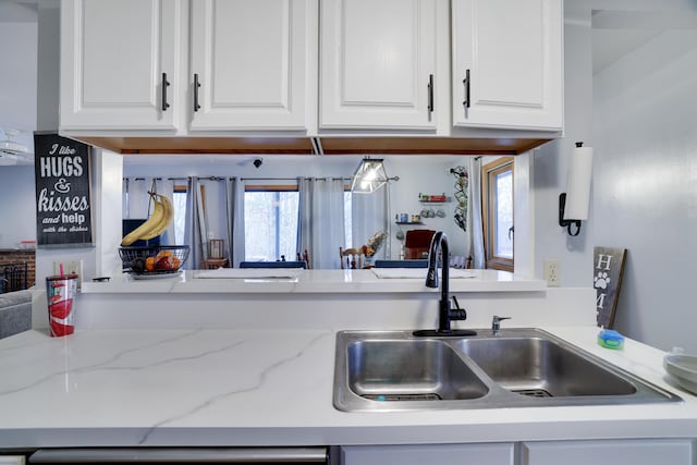 kitchen featuring a sink, white cabinetry, light stone counters, and dishwasher