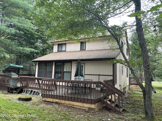 view of front facade featuring a deck and a shingled roof