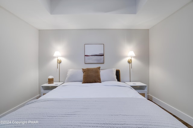 bedroom with baseboards and wood finished floors