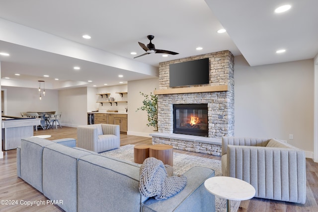 living area featuring light wood finished floors, a fireplace, a ceiling fan, baseboards, and recessed lighting