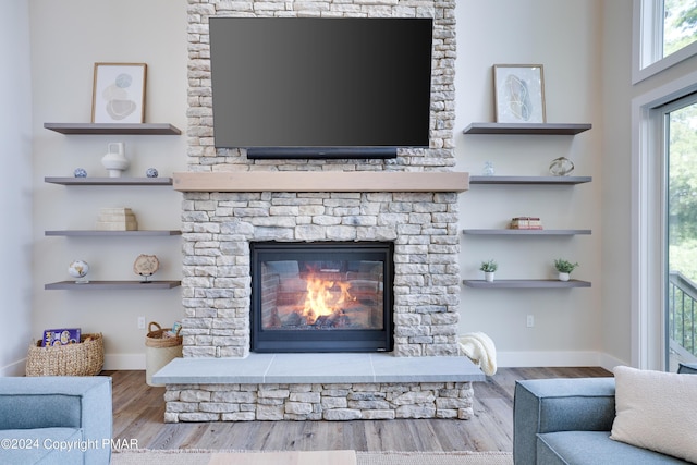 interior details with baseboards, wood finished floors, and a fireplace