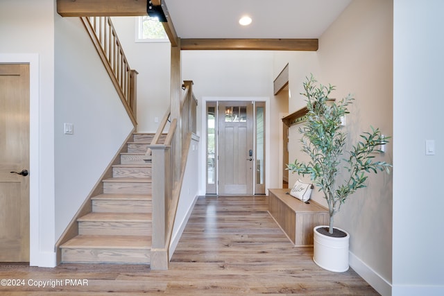 entrance foyer with baseboards, stairs, and wood finished floors