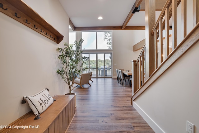 interior space featuring beam ceiling, wood finished floors, baseboards, stairway, and recessed lighting