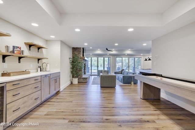 bar featuring light wood-style floors, beverage cooler, ceiling fan, recessed lighting, and a sink
