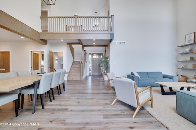 living room featuring visible vents, wood finished floors, stairway, a high ceiling, and recessed lighting