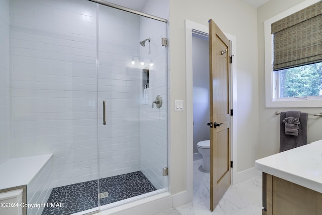 full bath with vanity, marble finish floor, toilet, baseboards, and a shower stall