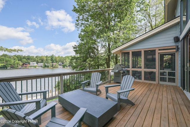 deck with a sunroom, a water view, and a grill