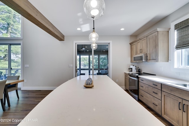 kitchen featuring light countertops, stainless steel microwave, range with electric cooktop, and a wealth of natural light