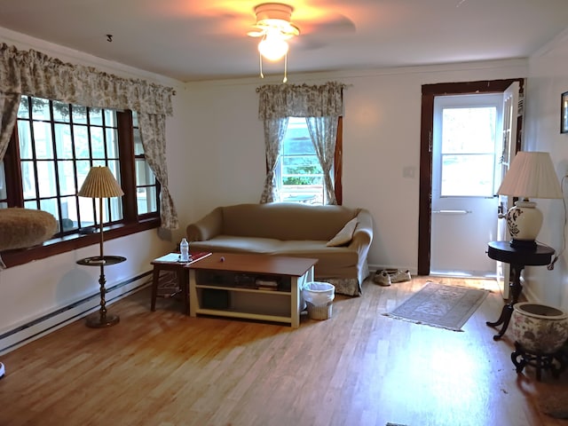 618 Mccabe Ln, Saylorsburg, PA 18353 - living area with healthy amount of natural light, wood finished floors, ceiling fan, a baseboard radiator, and ornamental molding