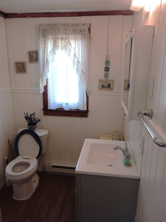 618 Mccabe Ln, Saylorsburg, PA 18353 - bathroom featuring a baseboard heating unit, wood finished floors, vanity, and a decorative wall