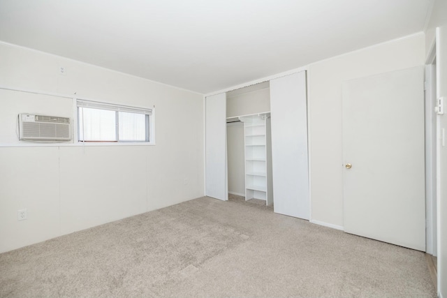 unfurnished bedroom featuring a wall mounted air conditioner, a closet, and carpet floors