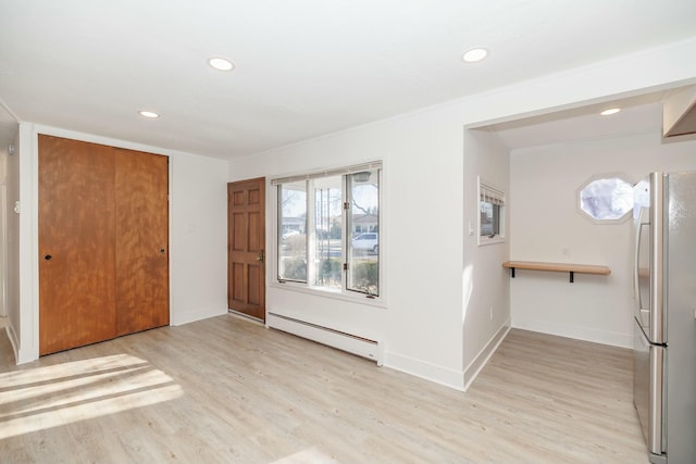 interior space featuring light wood finished floors, recessed lighting, baseboards, and a baseboard radiator