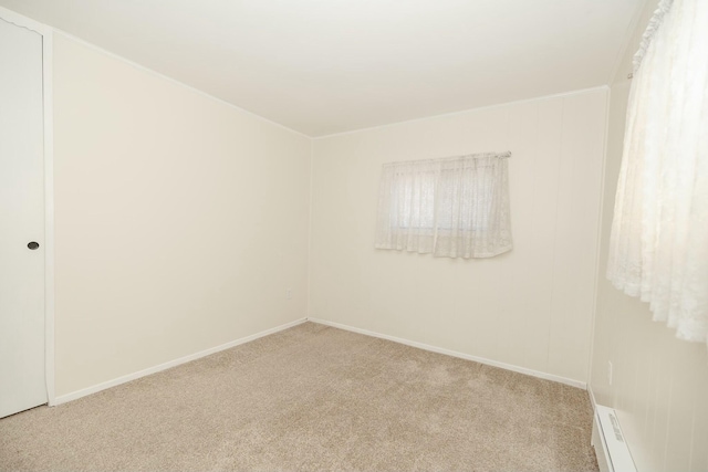 spare room with carpet flooring, baseboards, and a baseboard radiator