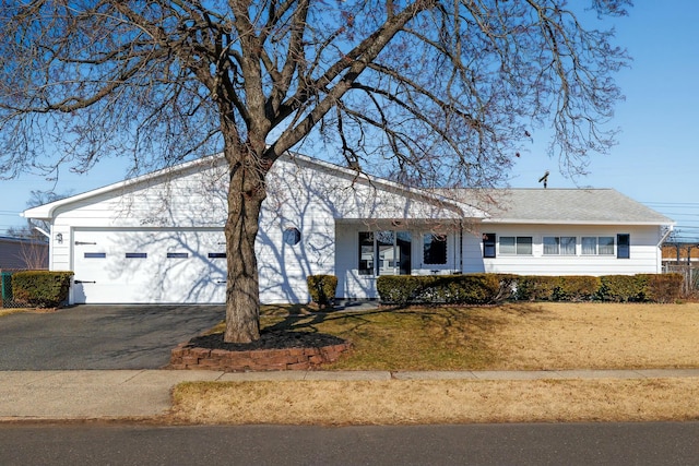 view of front facade with a garage, a front lawn, and driveway