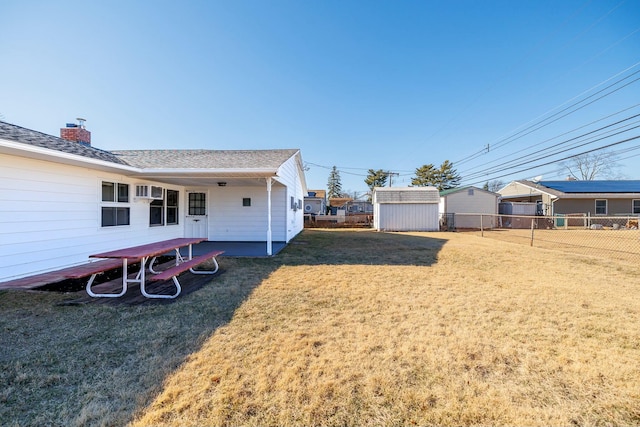 view of yard featuring an outbuilding, a storage unit, and fence