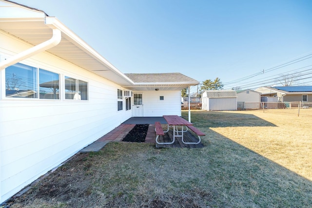 view of yard featuring a storage unit, an outdoor structure, and fence