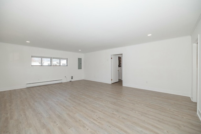 spare room featuring a baseboard heating unit, baseboards, light wood-type flooring, ornamental molding, and recessed lighting