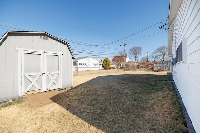 view of yard featuring an outbuilding, a storage unit, and fence