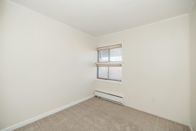 spare room featuring ornamental molding, baseboard heating, and light carpet