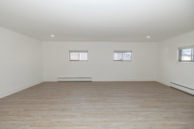 empty room featuring recessed lighting, light wood-type flooring, and a baseboard radiator