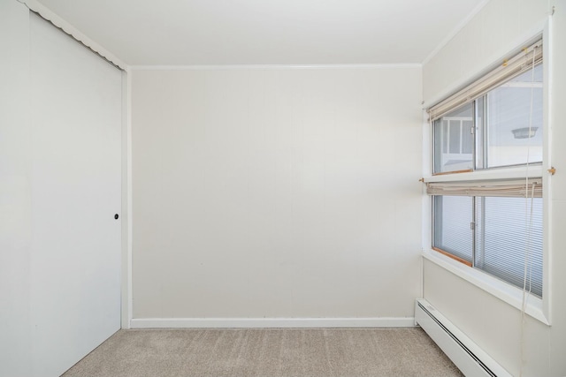 empty room with light carpet, crown molding, baseboards, and a baseboard radiator